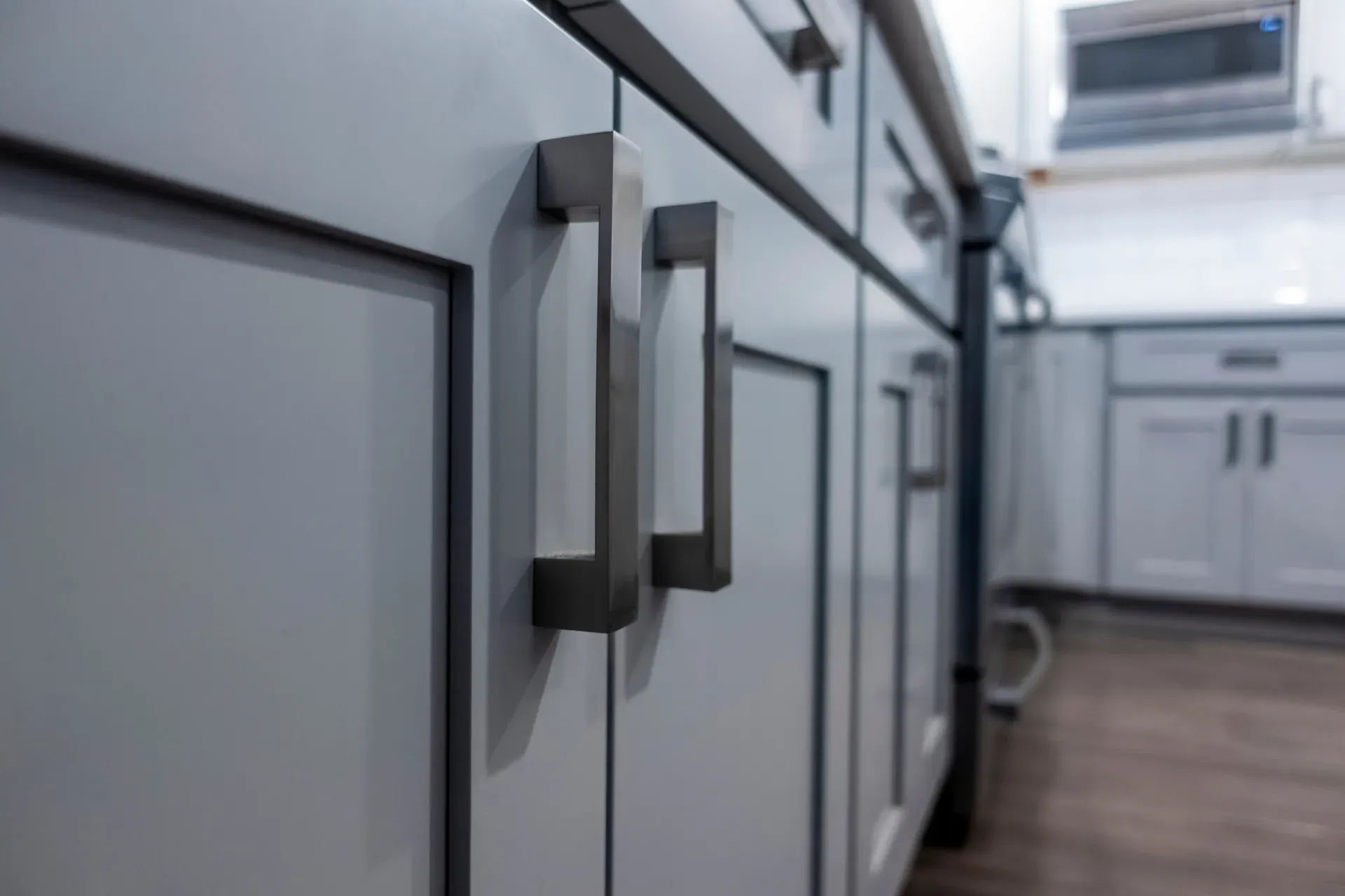 Flat grey cabinet doors with brushed steel bar pulls and an even, grainless finish